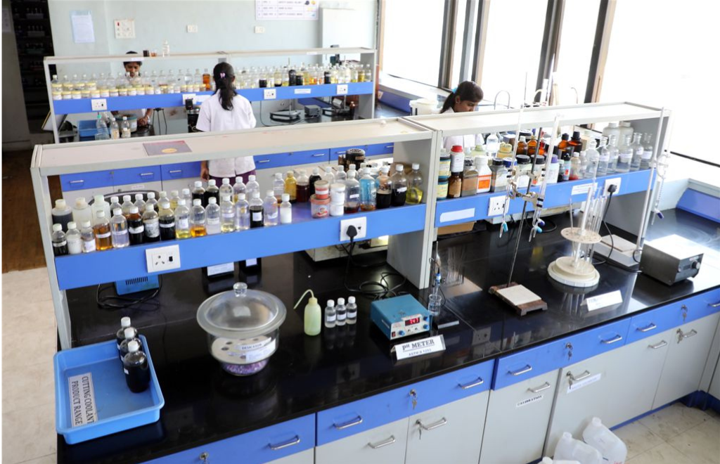 Industrial Lubricant Testing Laboratory with technicians conducting quality control, chemical analysis, and lubricant performance testing using advanced laboratory equipment.